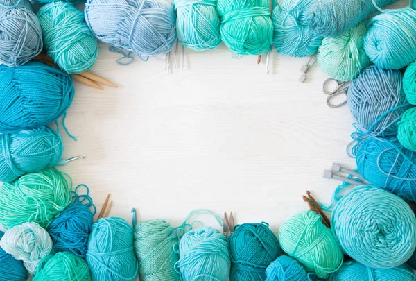 Yarn of green, turquoise, aquamarine and blue colors. White wood — Stock Photo, Image