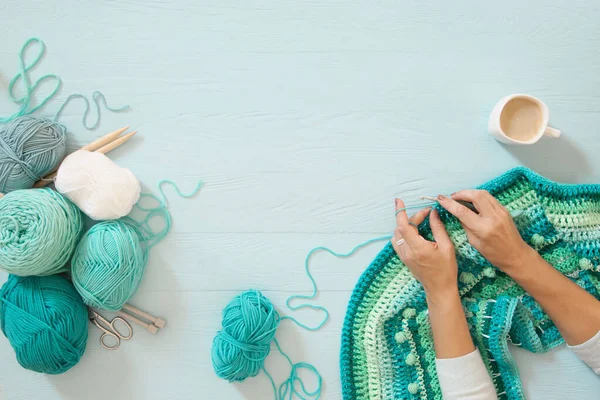 Women's hands are large. Woman crochets. Yarn of green, turquois — Stock Photo, Image