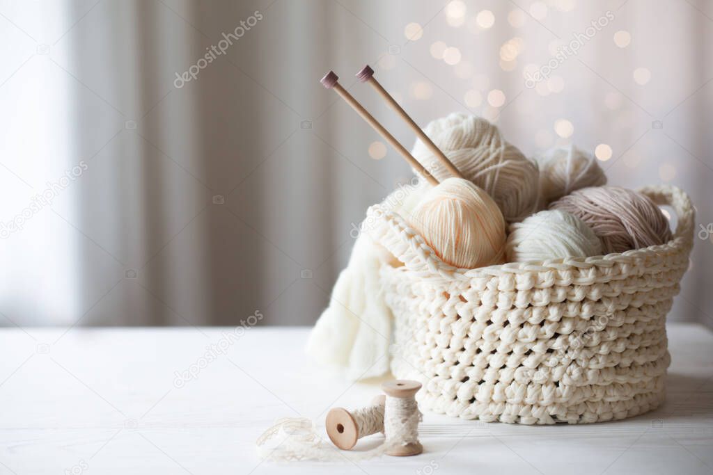 Cozy homely atmosphere. Female hobby knitting. Yarn in warm colors. Pink, peach, beige, white and green. The beginning of the process of knitting a women's sweater.