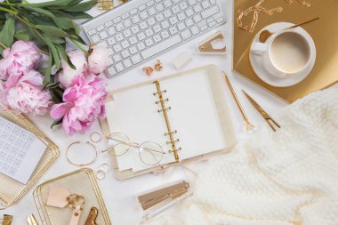 Kadın işi ya da blog yazma kavramı. Altın ve beyaz kırtasiye malzemeleri. İş ve yaratıcılık için kadınsı alan.