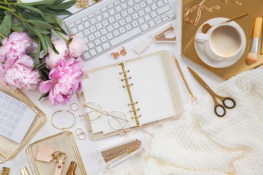 Kadın işi ya da blog yazma kavramı. Altın ve beyaz kırtasiye malzemeleri. İş ve yaratıcılık için kadınsı alan.