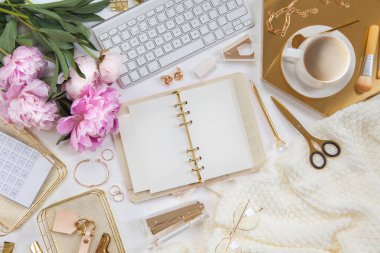 Kadın işi ya da blog yazma kavramı. Altın ve beyaz kırtasiye malzemeleri. İş ve yaratıcılık için kadınsı alan.