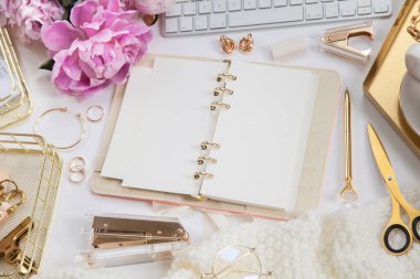 Kadın işi ya da blog yazma kavramı. Altın ve beyaz kırtasiye malzemeleri. İş ve yaratıcılık için kadınsı alan.
