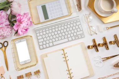 Kadın işi ya da blog yazma kavramı. Altın ve beyaz kırtasiye malzemeleri. İş ve yaratıcılık için kadınsı alan.