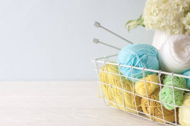 Duvarda mavi benekli duvar kağıdı var. Sepetin içindeki dikiş işi masanın üstünde. Uzayı kopyala Kadın hobisi..