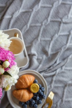 Yatakta sıcak kahvaltı, bir fincan kahve, yabanmersini, reçel ve mırıltı.