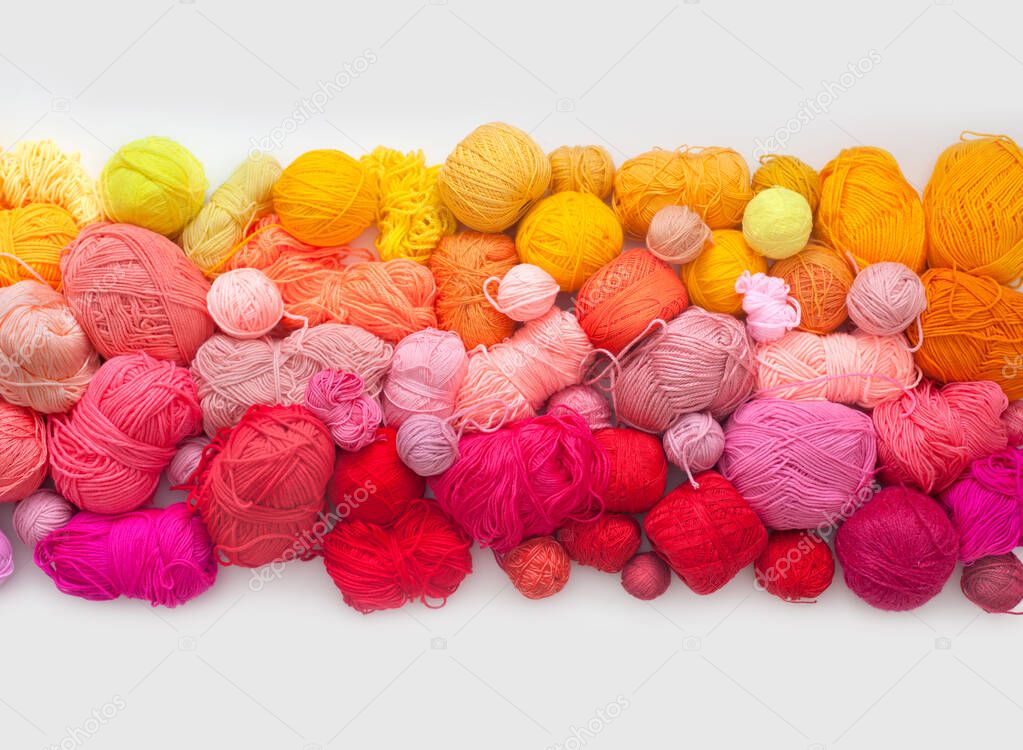 Many colorful balls of wool and cotton yarn for knitting. White background. Stretch and gradient. Rainbow layout.