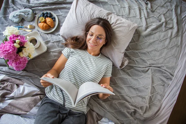 Kvinna Läsa Bok Eller Tidning Och Dricka Kaffe Frukost Sängen — Stockfoto