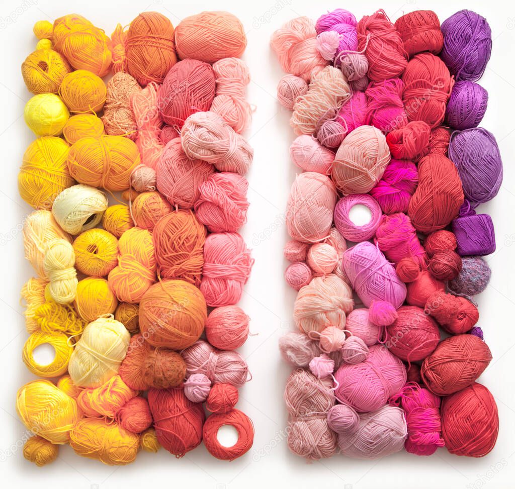 Many colorful balls of wool and cotton yarn for knitting. White background. Stretch and gradient. Rainbow layout.
