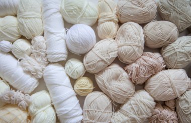 Many skeins and balls of yarn for knitting in natural and neutral colors and shades. Colorless, monochrome, modern style. clipart