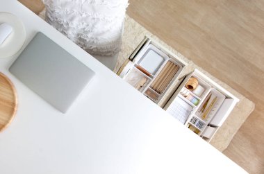 Kadın işyeri. Beyaz çalışma masası. Şık altın kırtasiyesi masanın çekmecesinde çok düzgün bir şekilde düzenlenmiştir. Japon saklama yöntemi.