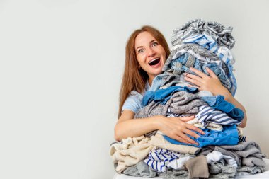 Kafkasyalı ev hanımı bir yığın kirli giysi tutuyor. Çamaşır. Kaos konsepti. Geçmişi. Meşgul kadın..