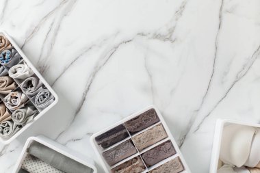 Tertipli ve düzenli katlanmış iç çamaşırları beyaz mermer arka planda düzenleyici çekmece bölmesinde. İç çamaşırlarının dökülmesi. Düzenli yer ve çekmece deposu. Kopyalama alanı.