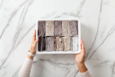 Kadın elleri katlanmış iç çamaşırlarıyla gardırop düzenleyicilerini yerleştiriyor. Katlanmış çoraplı çorap çekmecesi. Mükemmel ve düzgün bir kıyafet. Keten çekmece düzenleme çözümü. Mükemmeliyetçi..