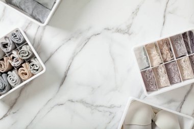 Tertipli ve düzenli katlanmış iç çamaşırları beyaz mermer arka planda düzenleyici çekmece bölmesinde. İç çamaşırlarının dökülmesi. Düzenli yer ve çekmece deposu. Kopyalama alanı.