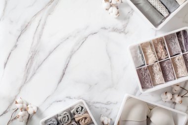 Tertipli ve düzenli katlanmış iç çamaşırları beyaz mermer arka planda düzenleyici çekmece bölmesinde. İç çamaşırlarının dökülmesi. Düzenli yer ve çekmece deposu. Kopyalama alanı.