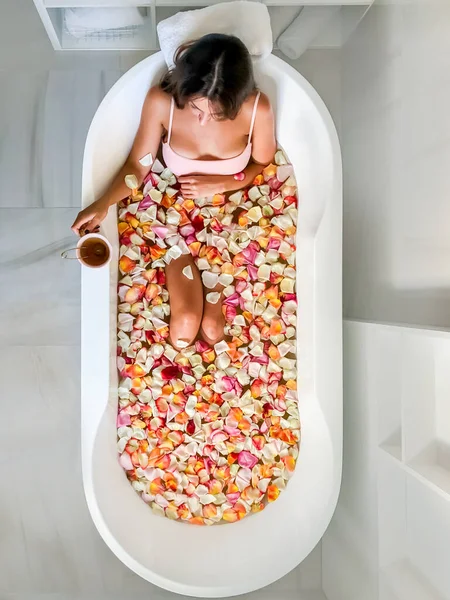 Fiatal Gyönyörű Lány Fekszik Fürdőben Rózsaszirmokkal Kilátás Fentről Rózsaszín Bögréből — Stock Fotó