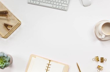 Ofis malzemeleri bilgisayar klavyesi, fare, kahve ve çiçekli beyaz arka planda daire içine alınmış. İş konseptine dönelim. Uzayı kopyala Anneler Günü. Özel günün kutlaması.