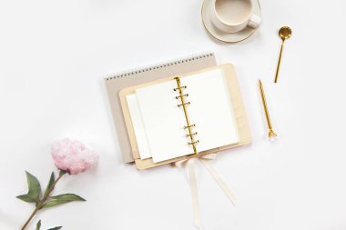 Üst kattaki defter, temiz çarşaflı, altın kalemli, bej derili günlük, beyaz masadaki bir fincan düz beyaz kahve. Kopya alanı olan eğitim ya da iş geçmişi. Minimalist ofis çalışma alanı