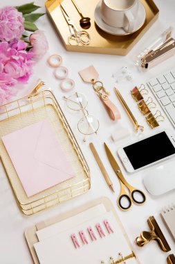 Modern aletler, cihazlar, kahve ve çiçeklerin olduğu düzgün düzenlenmiş ofis kırtasiyesi. Okul ve ofis malzemelerinin üst görüntüsü. Kullanışlı kopyalama alanı olan zarf metin veya logo için hazır.