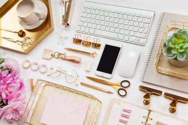 Modern aletler, cihazlar, kahve ve çiçeklerin olduğu düzgün düzenlenmiş ofis kırtasiyesi. Okul ve ofis malzemelerinin üst görüntüsü. Kullanışlı kopyalama alanı olan zarf metin veya logo için hazır.