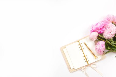 Ofis masasının klavyeli aksesuarları altın tepside kahve ve beyaz arka planda bitki. Evrak işleri için temiz çarşaflı günlük, altın kalem ve kağıt makası. Boşluğu kopyala