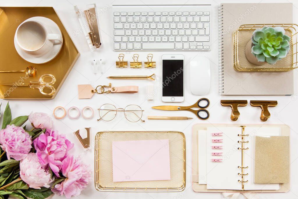 Neatly arranged office stationery with modern gadgets, devices, coffee and flowers on white desk. Top view of school or office supplies. Envelope with useful copy space ready for text or logo.