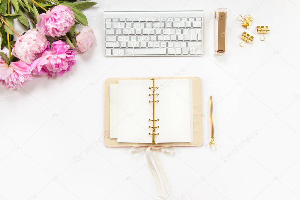 Neatly arranged office stationery with modern gadgets, devices, coffee and flowers on white desk. Top view of school or office supplies. Envelope with useful copy space ready for text or logo.