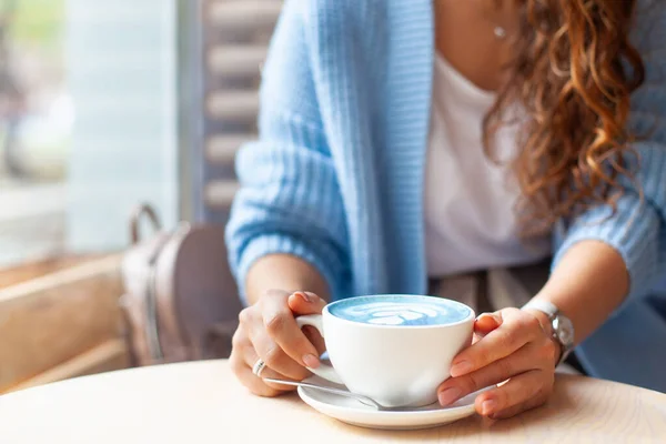 Odaklanamayan Kadın Elleri Elinde Bir Fincan Sıcak Kelebek Bezelye Latte — Stok fotoğraf