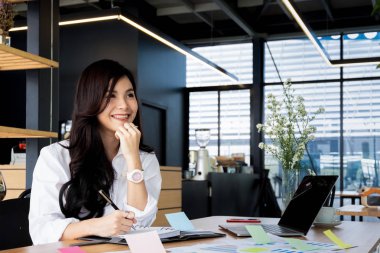 ofiste dizüstü bilgisayar belgeleri ile çalışan genç iş kadını ve yukarı bakıyor, iş kavramı