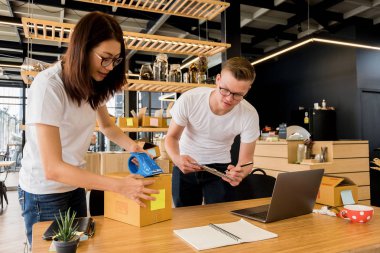 Bilgisayarlı mutlu insanlar hisse senedi ürünlerini kontrol etmek için çalışıyor. Evdeki internet ofisi, internet sektörü.