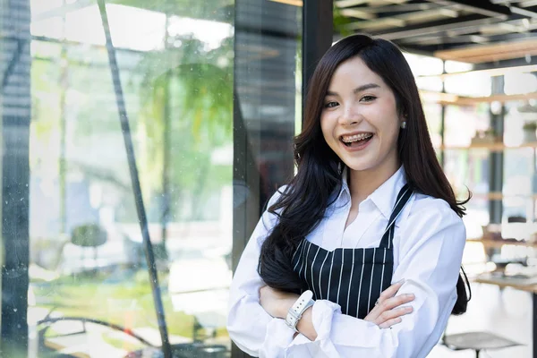 business owner standing in front of the coffee shop with a smile, owners business