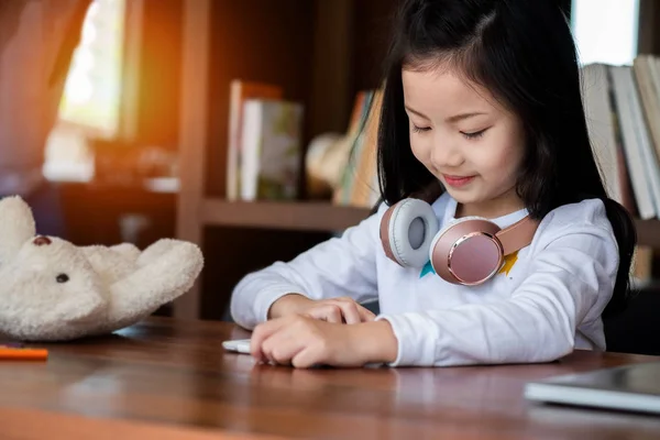 Şirin Kız Gülümsüyor Kütüphanede Tablet Akıllı Telefon Oynuyor Çocuk Konsepti — Stok fotoğraf