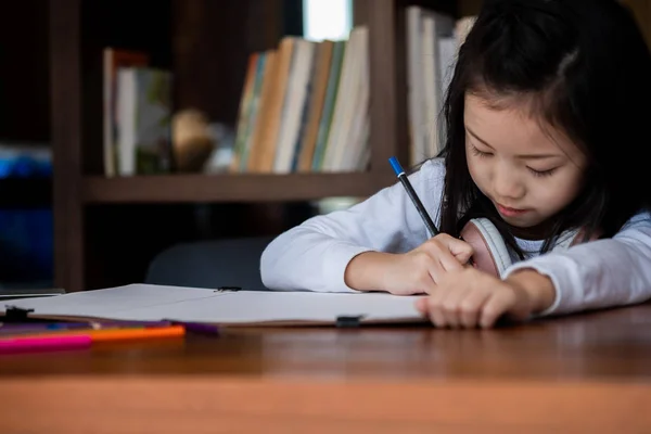 かわいい女の子は笑顔で座って図書館に本を書く子供の概念教育の概念 — ストック写真