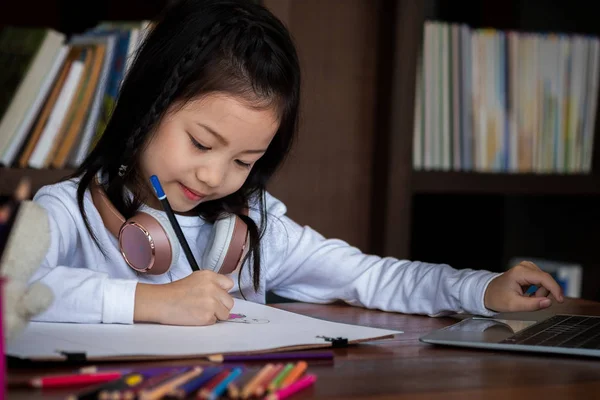 かわいい女の子は笑顔で図書館に本を描くことに座っています 子供の概念 教育の概念 — ストック写真