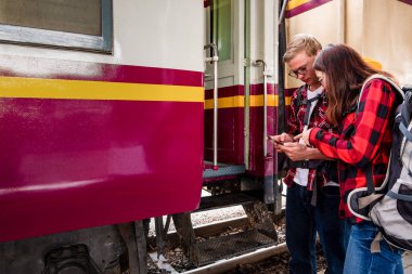 Birlikte tren istasyonunda tatilde olan mutlu genç çiftler, seyahat konsepti, çift konsepti 