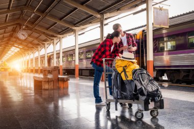 Birlikte tren istasyonunda tatilde olan mutlu genç çiftler, seyahat konsepti, çift konsepti 