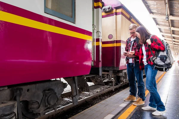 Birlikte tren istasyonunda tatilde olan mutlu genç çiftler, seyahat konsepti, çift konsepti 