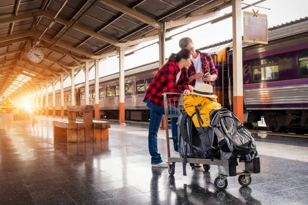 Birlikte tren istasyonunda tatilde olan mutlu genç çiftler, seyahat konsepti, çift konsepti 