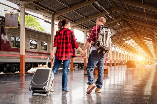 Birlikte tren istasyonunda tatilde olan mutlu genç çiftler, seyahat konsepti, çift konsepti 