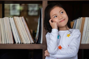 Tatlı kız gülümsedi ve odaya baktı. Çocuk konsepti, eğitim konsepti.