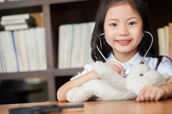 young girl enjoys playing with stethoscope with toy, children concept, medical concept