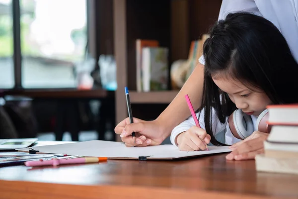 かわいい女の子は笑顔で図書館に本を描くことに座っています 子供の概念 教育の概念 — ストック写真