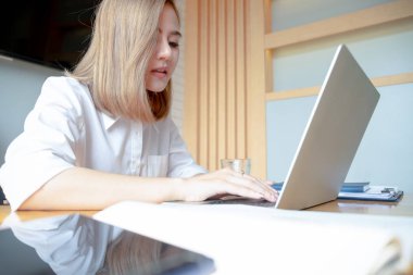 cep telefonu dizüstü bilgisayar ve documen ile çalışan genç iş kadını