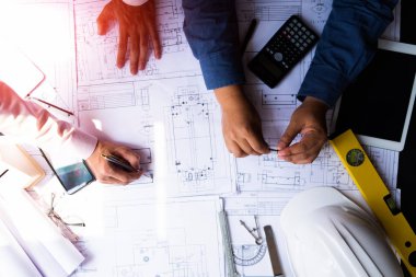 mühendisler plan üzerinde bina işaret ve dizüstü bilgisayar kullanarak 