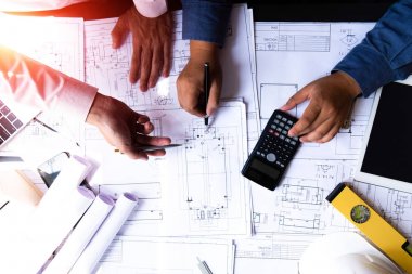 mühendisler plan üzerinde bina işaret ve dizüstü bilgisayar kullanarak 