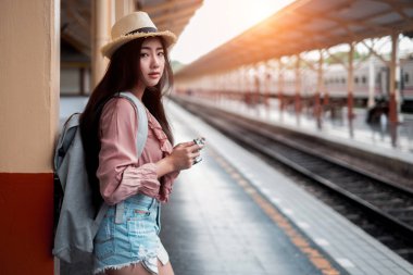 Sırt çantalı gülümseyen kadın gezgin elinde antika kamerayla...