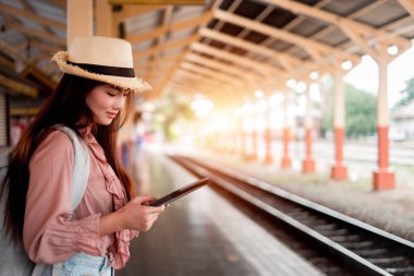 Tatil r tablet tutan sırt çantası ile Gülümseyen kadın gezgin