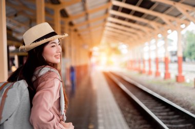 Gülümseyen kadın gezgin tatil rel sırt çantası ile sol aranıyor