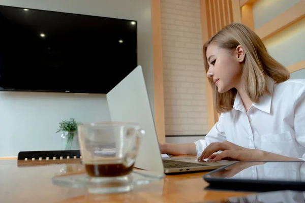 Junge Geschäftsfrau arbeitet mit mobilem Laptop und Dokumenten in — Stockfoto